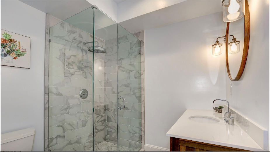 Walk in shower with stone surround in small bathroom in San Diego by Honeycomb